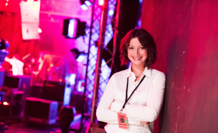 Eventmanagerin lehnt an der Bühne