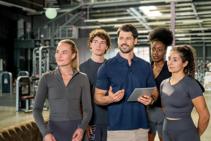 Ausbilder mit Gruppe Azubis im Fitnessbereich