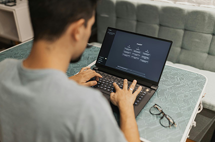Kamera schaut Mann am Laptop über die Schulter