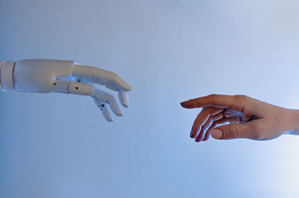 Roboterhand und Menschenhand kommen aufeinander zu