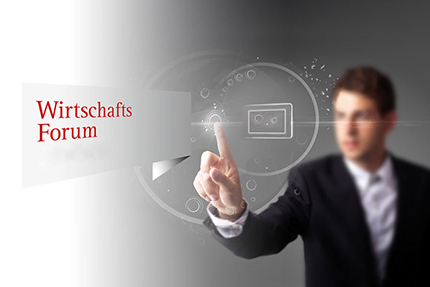Mann steht an schibe und berührt den Schriftzug Wirtschaftsforum