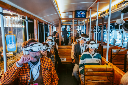 Leute mit VR-Brillen in einer historischen Straßenbahn