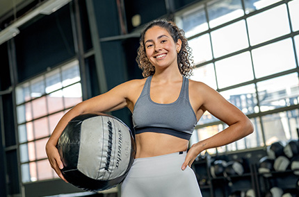 Trainierende Frau mit einem Ball unterm Arm