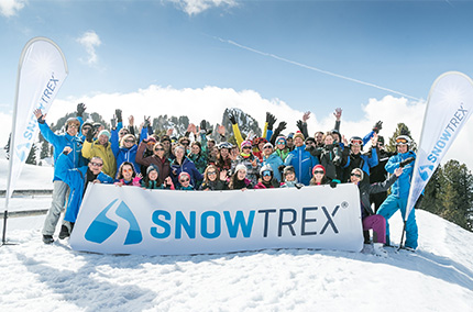Team im Schnee hält Banner mit der Aufschrift "Snowtrex"